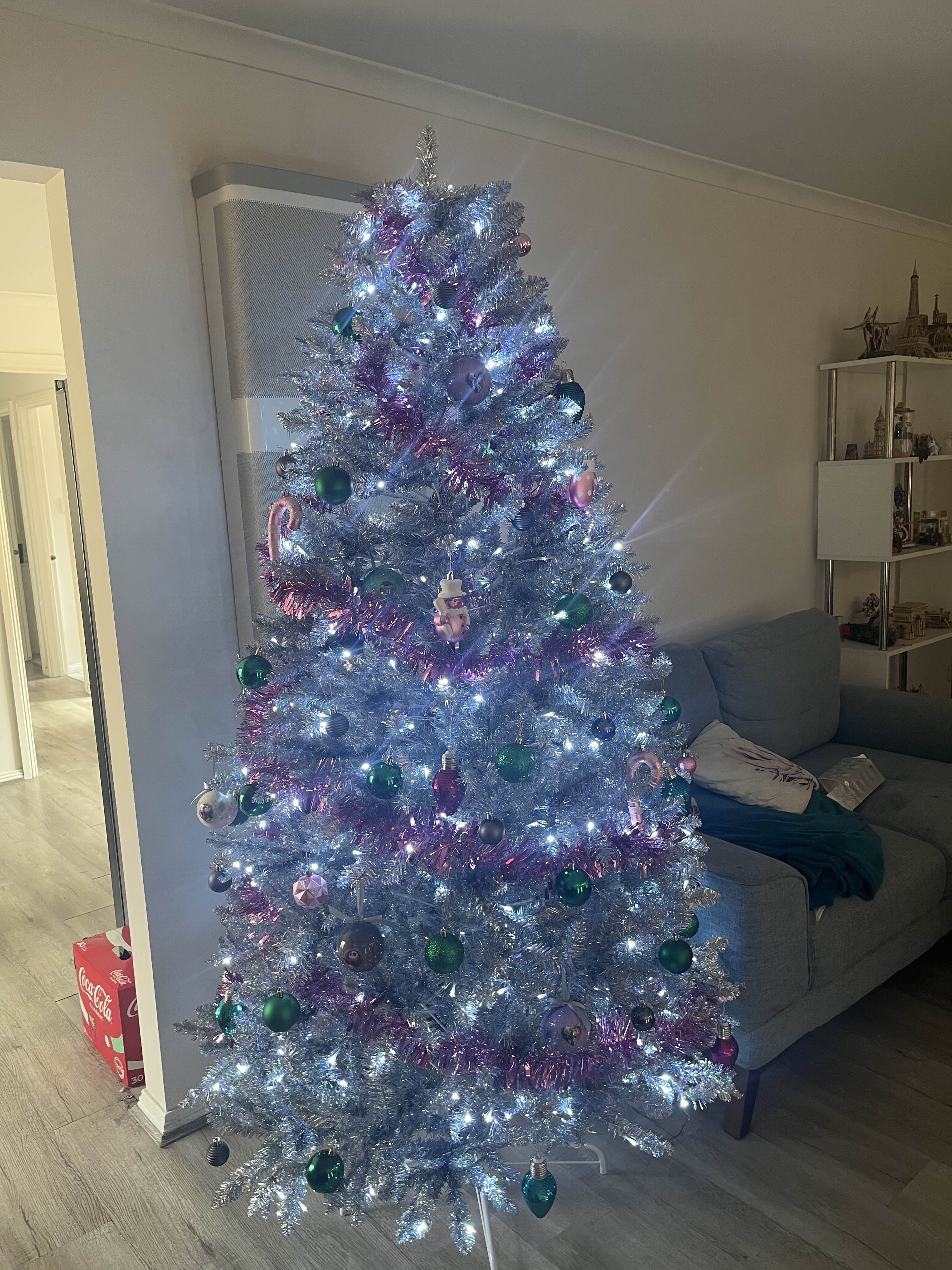 A photo of a large decorated artificial tree inside a house